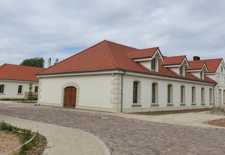 Odrestaurowana zabudowa folwarczna z brukowanym placem
