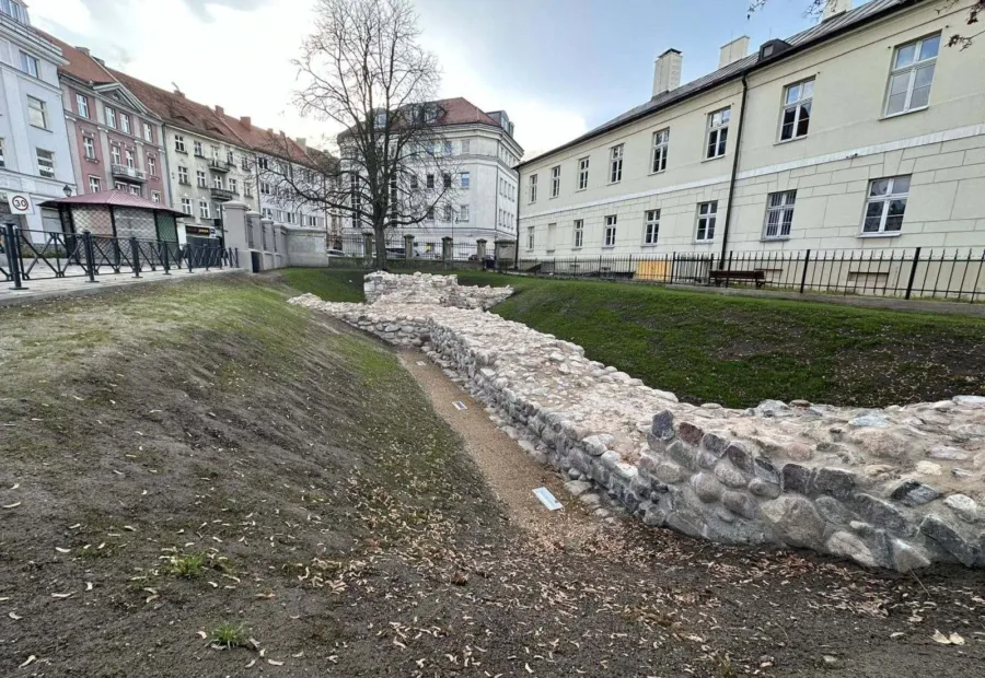 Makieta Zamku Kazimierzowskiego z brązu na tle odsłoniętych murów