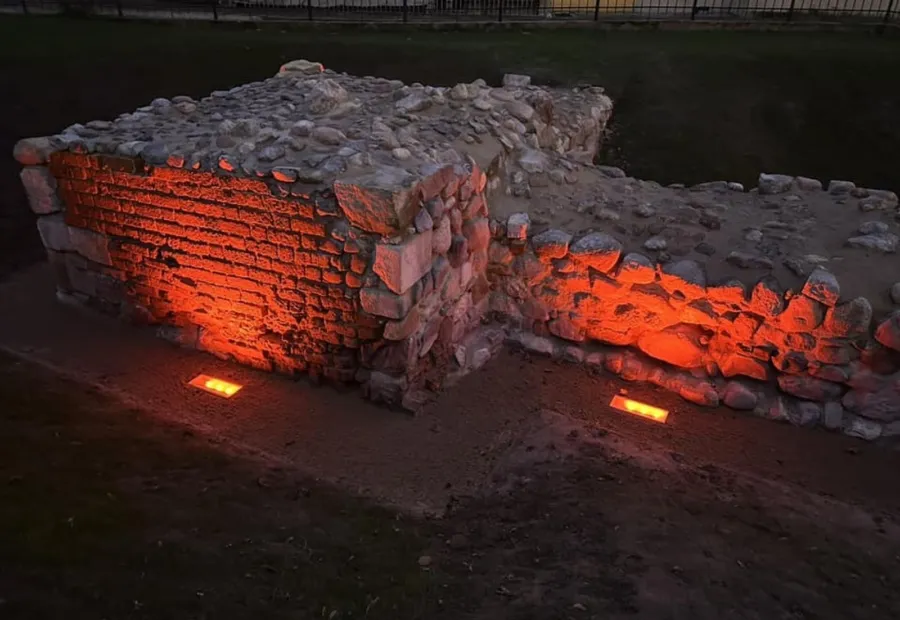 Fragment murów po renowacji z uporządkowanym otoczeniem