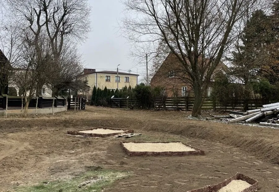 Strefa edukacyjna z rzeźbą przy drewnianym kościele